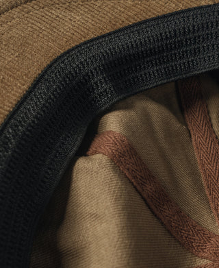 Khaki biker cap interior edge with black elastic trim and lining.