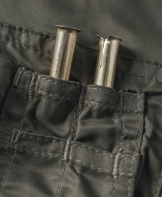 Olive utility pocket with snap buttons and two metal tool-like tubes
