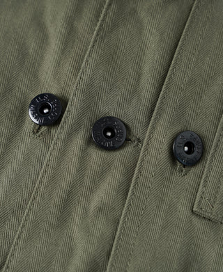 Olive jacket front close-up with multiple black snap buttons