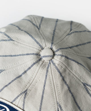 Gray newsboy cap crown with radial seams and blue railroad stripe pattern