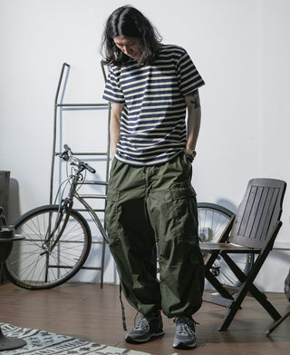 Olive arctic trousers shell on model, wide leg with drawstring cuff details