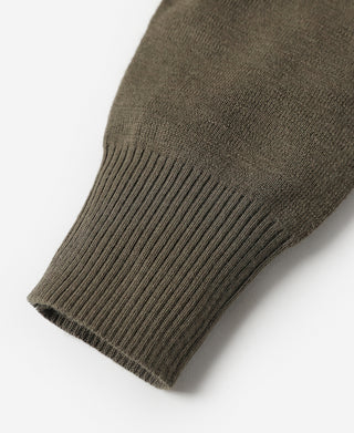 Close-up of olive wool sweater sleeve cuff ribbing