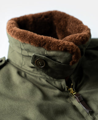 Olive jacket neck opening with brown shearling trim and zip pull tab