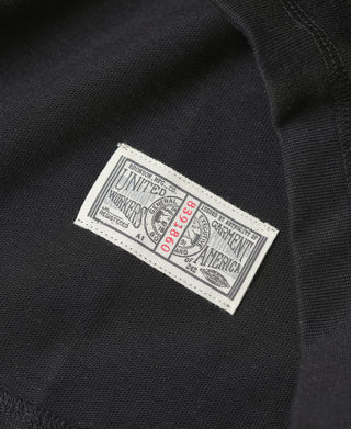 Black henley shirt with vintage label at sleeve seam.