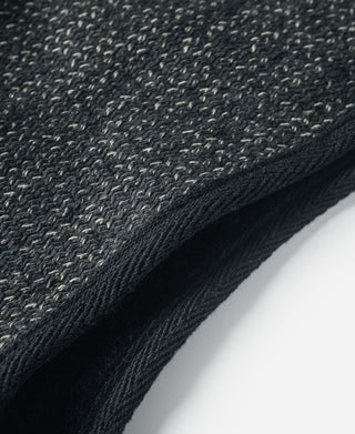 Wool vest hem edge with stitched trim on dark salt-and-pepper fabric
