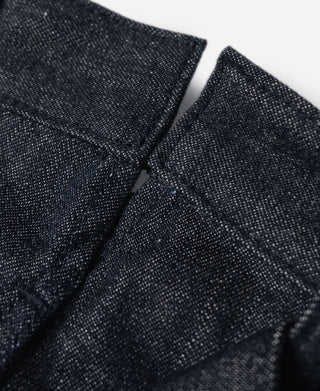Close-up of dark navy denim belt loops and cross-body pocket stitching