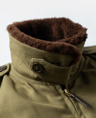 Khaki flight jacket neck and zipper close-up with brown shearling lining and throat strap.