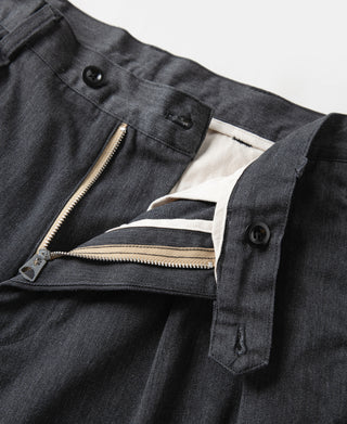 Dark gray chino trousers showing front zipper, button, and pleated front