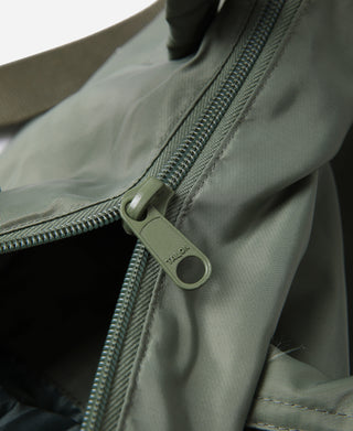 Olive tote bag zipper with round metal pull and stitched fabric seam detail