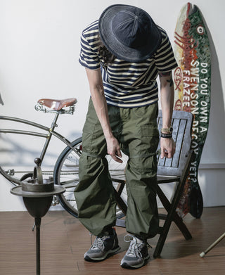 Olive arctic trousers shell on model, cargo pocket flaps and drawstring hems