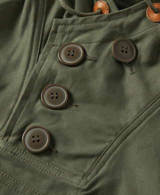 Olive parka chest pocket close-up with four tan-trim buttons and stitched flap