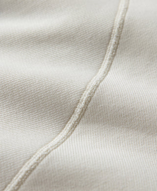 White raglan sweatshirt side seam detail with stitched fabric edge