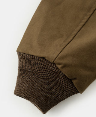 Brown bomber jacket sleeve cuff with ribbed knit hem and stitched sleeve opening.