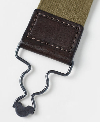 Dark leather suspender clip with stitched panel and wavy metal spring