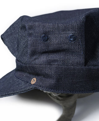 Indigo denim cap close-up with brass snap and textured top stitching