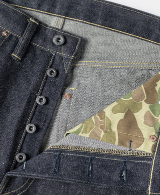 Indigo denim waistband close-up with belt loops and button fly