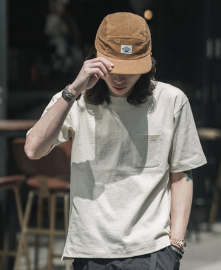 Khaki corduroy 5-panel cap worn while adjusting it