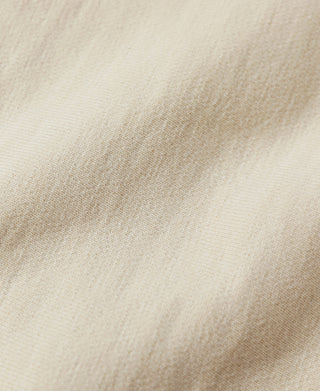 Apricot reverse-weave hoodie fabric close-up with fine texture.