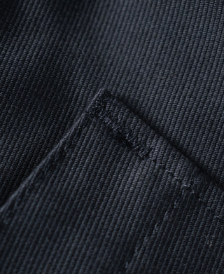 Navy deck jacket pocket close-up with stitching and small branding mark