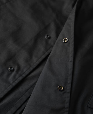 Black all-weather trench coat front placket with visible snap buttons