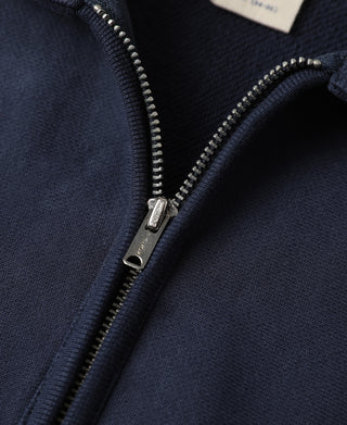Navy half-zip sweatshirt with silver zipper pull and textured fabric