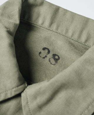 Olive fatigue jacket shoulder panel with printed marking and textured weave