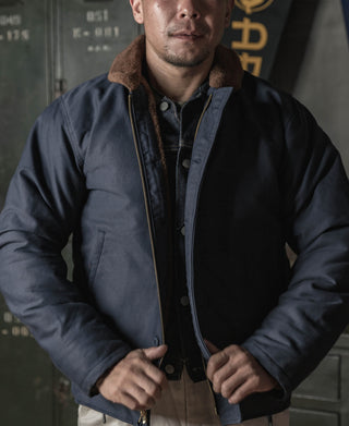 Navy N-1 deck jacket with shearling collar, front snap placket, and rib-knit trim