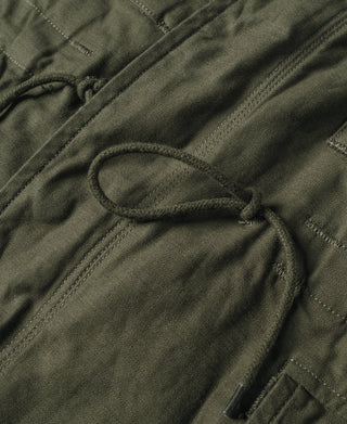 Olive field jacket hem drawstring channel with stitched fabric and dark zipper pull