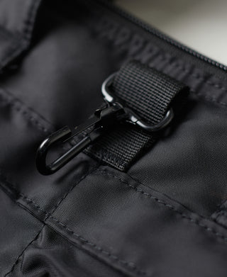 Black nylon helmet bag detail showing zipper pull and nylon webbing tab