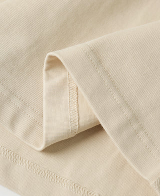 Apricot henley sleeve cuff with stitched hem and smooth fabric texture
