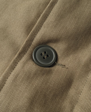Dark gray button on khaki fabric panel