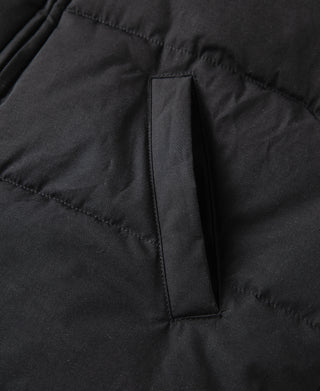Black quilted vest with vertical pocket opening and inner fabric trim