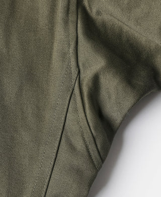 Olive field jacket fabric close-up with seam and stitched panel edges