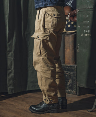 Khaki field pants on a model, side view with multiple cargo pockets.