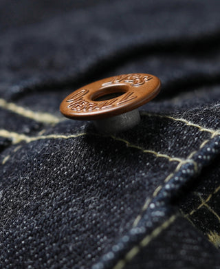 Brown denim jacket button close-up with engraved “N&S Universal” text