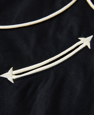 Black western shirt fabric detail with white arrow embroidery along seam