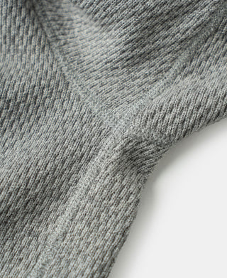 Gray waffle thermal shirt sleeve seam and ribbed cuff detail, knit texture close-up