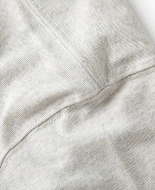 Oatmeal T-shirt side seam close-up with stitched knit panel.