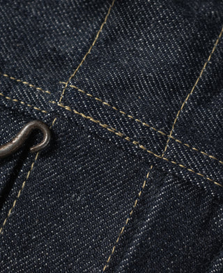 Indigo denim jacket seam detail with metal loop and contrast yellow stitching