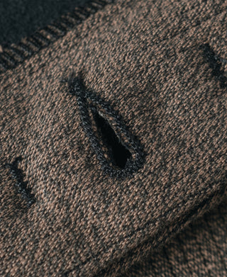 Brown salt-and-pepper striped pants close-up of dark thread and stitch detail