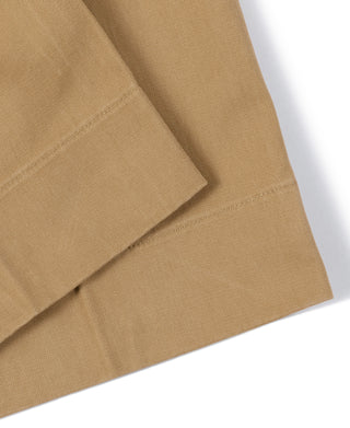 Tan chino trouser leg with clean crease and angled side seam