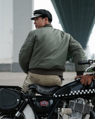 Olive MA-1 flight jacket on model from the back, ribbed hem and sleeve cuffs visible