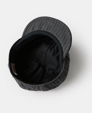 Black and gray newsboy cap showing interior lining and sewn crown panel.