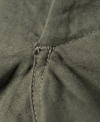 Olive utility shorts close-up of fabric panel seam and curved reinforcement stitch