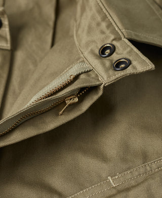Khaki green jacket front placket with zipper and two metal snap buttons