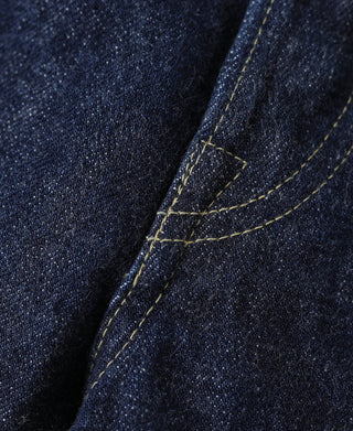 Indigo denim jeans side seam and pocket corner with contrast topstitching, close-up
