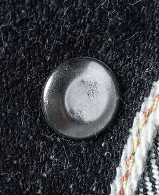 Indigo selvedge denim jacket button on dark textured fabric