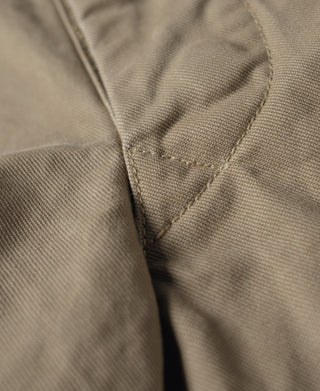 Khaki combat pants with angled stitched seam at the inner leg