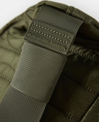 Close-up of olive strap webbing attachment inside padded bag