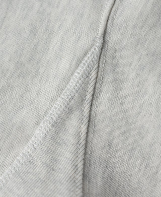 Light gray T-shirt shoulder seam and side panel stitching close-up